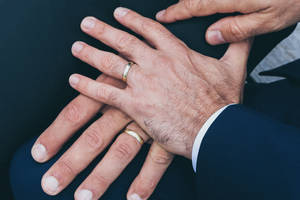 兩隻手緊握在一起，手指上戴著結婚戒指。 — 婚禮 壁紙