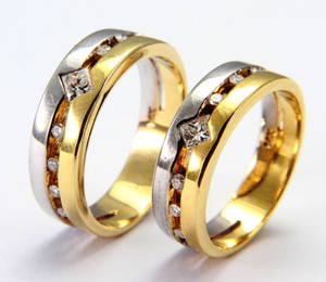 兩隻金色和銀色的結婚戒指，帶有鑽石。 — 白天 壁紙