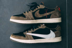 兩雙Travis Scott x Nike Air Jordan 1運動鞋掛在灰色牆上。 — 球鞋 壁紙