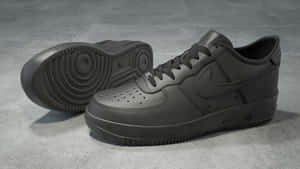 灰色混凝土地板上的兩雙黑色Nike Air Force 1運動鞋。 — 中性 壁紙