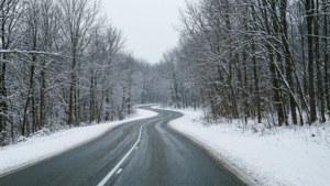 一條蜿蜒的道路穿越雪白的冬季景色。