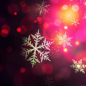 發光的雪花在紅色、粉紅色和金色燈光的節日散景背景下飄浮。 — 可愛聖誕 iPhone 壁紙
