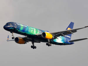 冰島航空極光設計飛機在多雲天空下降落 — 晴朗天空 壁紙