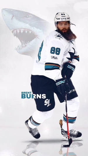 冰球運動員 Brent Burns 身穿鯊魚隊制服，身後冰面上有鯊魚圖案。 — 運動 壁紙