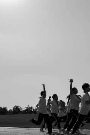 孩子們在開闊的天空下，舉起手臂在小路上奔跑。 — 健身 壁紙