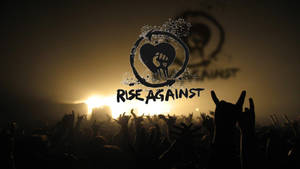Rise Against 演唱會上，人群在舞台燈光下舉起雙手。 — 岩石 壁紙