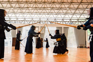 劍道戰士穿著防護裝備，在現代室內道場中用竹刀練習。 — 運動 壁紙