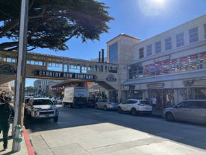 加州蒙特雷的 Cannery Row，停泊的車輛和行人，天空湛藍。 — 街頭 壁紙