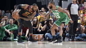 勒布朗·詹姆斯在NBA比賽中運球突破波士頓塞爾提克防守球員。 — 克里夫蘭騎士隊 壁紙