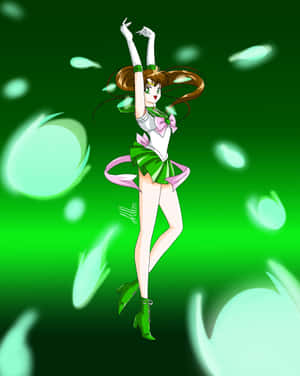Sailor Jupiter 穿著綠色和粉紅色制服，在發光的綠色粒子中舉起雙臂擺姿勢。 — Apple Watch Ultra 壁紙