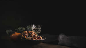 碗中的切片石榴，旁邊有完整水果和玻璃杯，置於木桌上。 — 午夜 壁紙