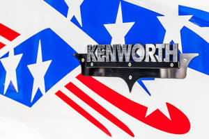 鍍鉻 Kenworth 卡車標誌，帶有紅、白、藍星條紋圖案。 — 肯沃斯 壁紙