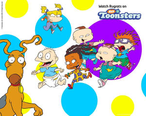 Rugrats 角色和他們的狗在色彩繽紛的圓點背景上玩耍。 — 可愛卡通 壁紙
