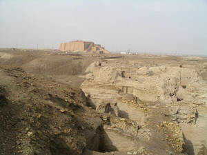 沙漠景觀中的古代金字形神塔遺跡，散落著磚地基。 — 伊拉克 壁紙
