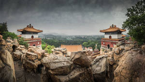 岩石懸崖上的寺廟建築，俯瞰著暴風雨天空下的迷霧山谷。 — 北京 壁紙