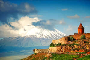 懸崖上的古老石堡，背景有積雪山峰 — 山景 壁紙