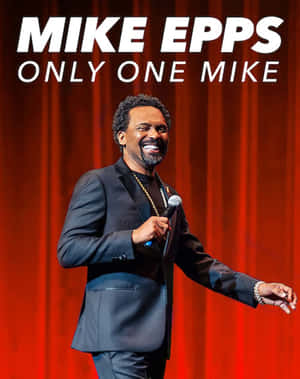 喜劇演員 Mike Epps 在舞台上手持麥克風微笑。 — 4:5 壁紙