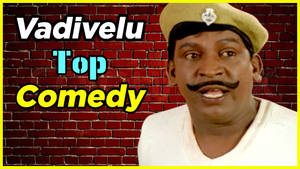 喜劇演員Vadivelu穿著制服帽微笑，背景為磚牆，上有「Top Comedy」文字。 — 黑白小丑 壁紙