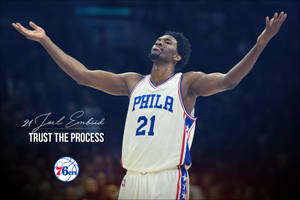 喬爾·恩比德身穿白色球衣高舉雙臂慶祝，附有「Trust the Process」文字。 — NBA 壁紙