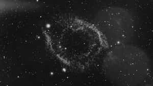 在星空中旋轉的宇宙星雲，帶有發光粒子。 — 簡約暗黑美學 壁紙