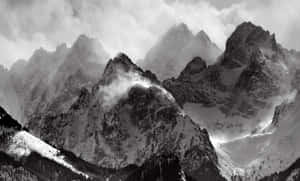 積雪的山峰在霧中升起，森林斜坡呈現單色。 — 冬季風景 壁紙