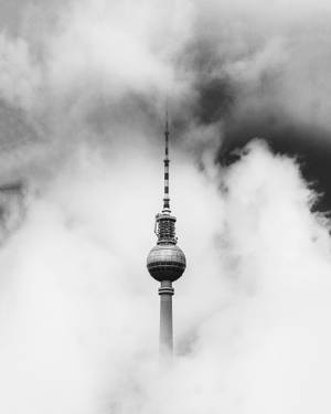 柏林電視塔從厚雲中浮現的黑白照片。 — 柏林 壁紙