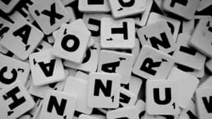 Scrabble 遊戲字母牌以黑白散落。 — 字體排印 壁紙