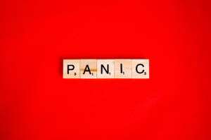 木製Scrabble字母塊在紅色背景上拼出恐慌。 — 驚爆危機 壁紙
