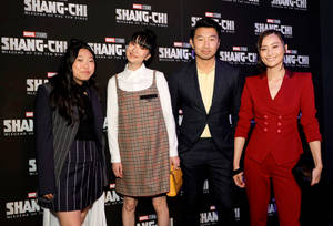 四位微笑的人們在Shang-Chi電影首映活動中穿著正式服裝。 — 尚氣 壁紙