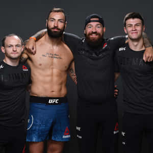 四位男性UFC拳手穿著運動服一起擺姿勢，刺青清晰可見。 — 運動 壁紙
