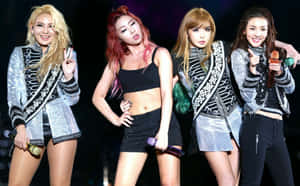 四位女K-pop偶像身穿銀色外套和黑色服裝在舞台上表演。 — 2NE1 壁紙