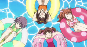 四個動漫女孩漂浮在泳池中的色彩繽紛浮圈上。