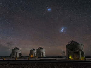 星空下四個天文台圓頂，可見銀河和星雲。 — 宇宙 壁紙