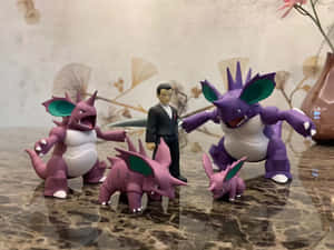 四個 Pokémon 公仔和一個穿西裝的男人在大理石表面上。 — 寶可夢 高畫質 壁紙