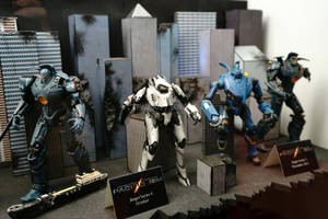 四個 Pacific Rim Jaeger 動作人偶在帶有標籤的城市景觀立體模型中展示。 — 機器人 壁紙
