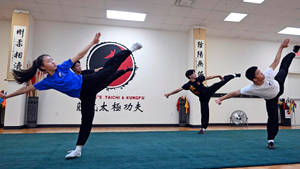 四名武術學生在道場練習高踢腿。 — 運動 壁紙