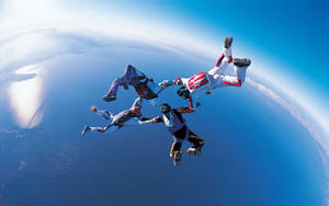 四名跳傘者自由落體，下方可見地球曲線 — 極限運動 壁紙