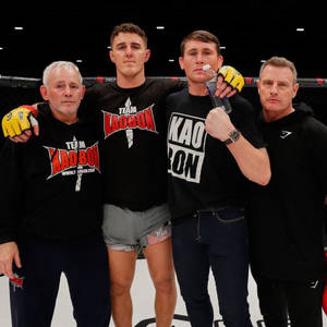 四名MMA拳手和教練在八角籠內與獎盃合影。 — 運動 壁紙
