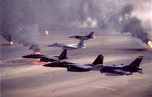 四架戰鬥機飛越燃燒的沙漠戰場，下方煙霧和火焰。 — 軍事動圖 壁紙