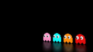 四隻來自Pacman的彩色像素鬼魂排列在黑暗的表面上。 — 酷炫遊戲 壁紙