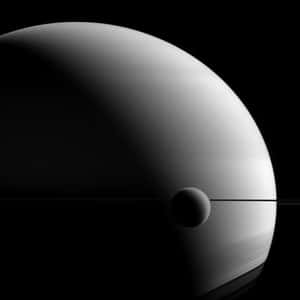 土星及其衛星被光環框住，背景是黑暗的宇宙。 — iPad (A16) 壁紙