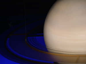 土星及其標誌性光環在黑暗太空背景下發出深藍色光芒。 — 土星 壁紙