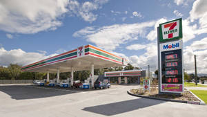 7 Eleven Mobil加油站在藍天白雲下顯示燃油價格。 — 加油站 壁紙