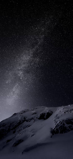 在有銀河的星空下的雪白山頂。 — 深色模式 壁紙