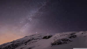 在可見銀河的星空夜空下的雪山峰。 — 美學 Mac 壁紙