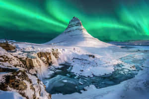 夜晚綠色北極光下的雪山和瀑布。 — 星空動畫 壁紙