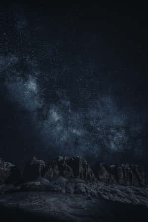在可見銀河系的星空夜空下，黑暗崎嶇的山脈。 — Oppo Pad Mini 壁紙