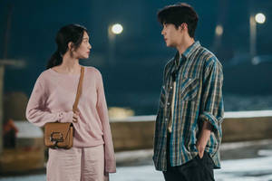 夜晚街燈下，一名男子和一名女子站得很近，互相凝視。 — 車銀優 GIF 壁紙