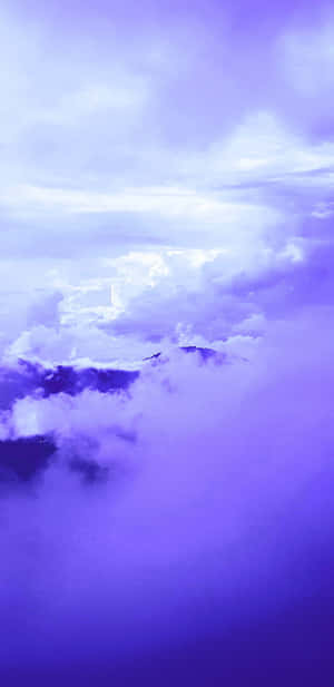 紫色雲層在暮色天空下圍繞著山峰旋轉。 — Pixel 4 壁紙