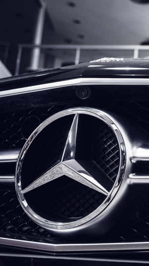 汽車格柵上帶有鍍鉻飾面的賓士星形標誌特寫。 — Mercedes Benz C300 壁紙